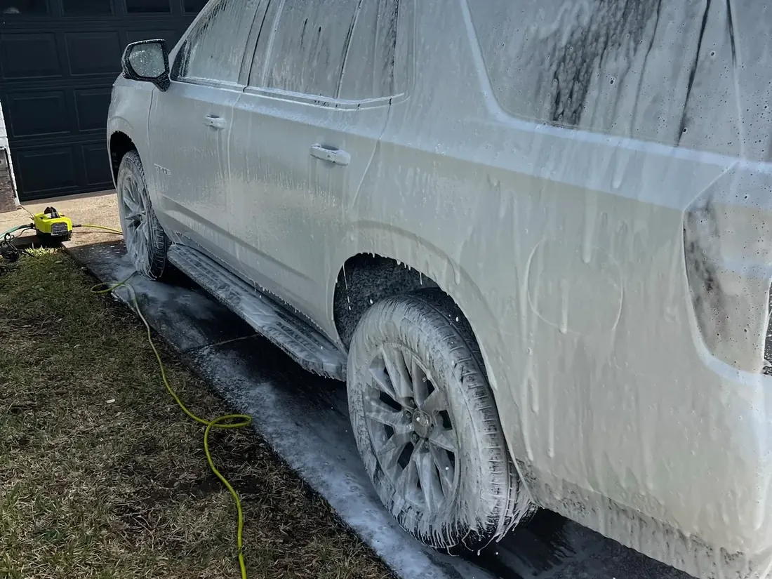 White Chevrolet Tahoe covered in foam during mobile detailing